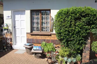 a house with a window and a bench in front of it at Grace Accommodation Centurion in Centurion