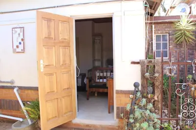 an open wooden door of a house with a table at Grace Accommodation Centurion in Centurion