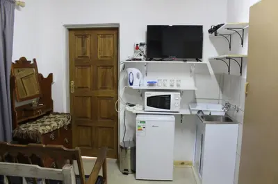 a small kitchen with a microwave and a refrigerator at Grace Accommodation Centurion in Centurion
