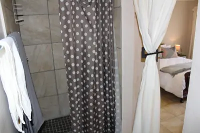 a shower curtain with polka dots on it in a bathroom at Grace Accommodation Centurion in Centurion