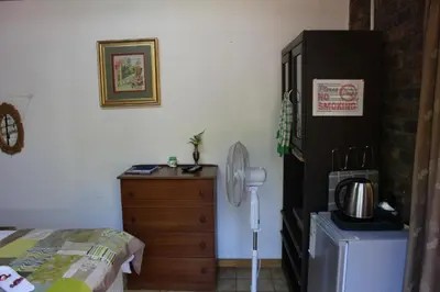 a bedroom with a bed and a wooden dresser at Grace Accommodation Centurion in Centurion