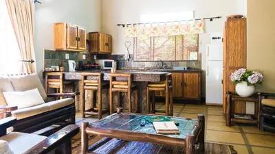 a living room with a kitchen with a table at Moholoholo Ya Mati in Kampersrus AH