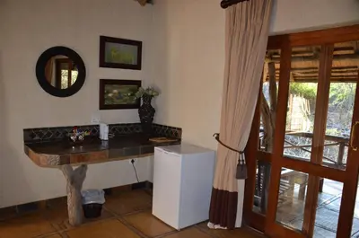 a kitchen with a counter and a sink and a refrigerator at Moholoholo Forest Camp in Hoedspruit