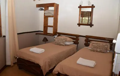 two twin beds in a room with at Moholoholo Mountain View in Hoedspruit