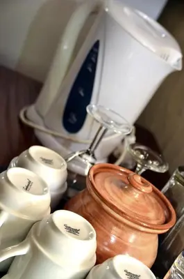a group of white cups and a tea kettle at Moholoholo Mountain View in Hoedspruit
