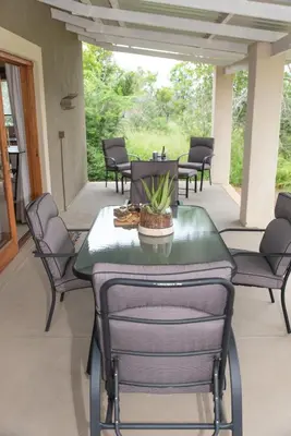 a patio with chairs and a table with a plant on it at Route 40 in Hoedspruit