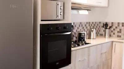 a kitchen with a black oven and a microwave at 3 Lux Suites in Middelburg
