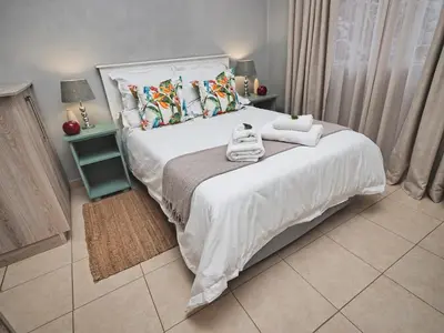a bedroom with a bed with towels on it at Poinsettia family Cottage in Hazyview