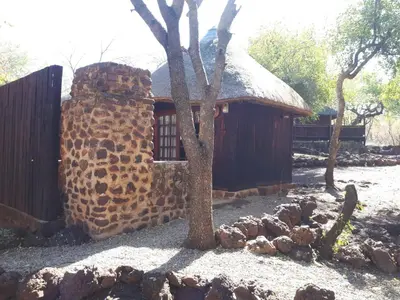 a stone building with a tree in front of it at ThabaNkwe Bushveld Inn in Thabazimbi