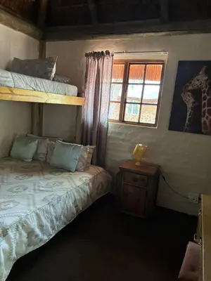 a bedroom with two bunk beds and a window at ThabaNkwe Bushveld Inn in Thabazimbi