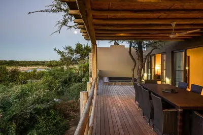a wooden deck with a table and chairs on a house at Mjejane Bush Camp by Dream Resorts in Hectorspruit