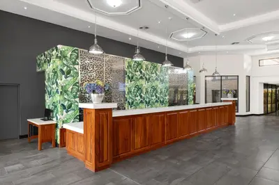 a lobby with a reception desk and flowers on the wall at Park Hotel Mokopane in Mokopane