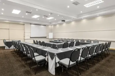 a conference room with tables and chairs and a whiteboard at Park Hotel Mokopane in Mokopane