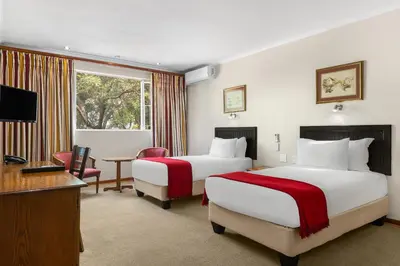 a hotel room with two beds and a television at Park Hotel Mokopane in Mokopane