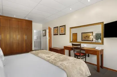 a hotel room with a bed and a desk and a computer at Park Hotel Mokopane in Mokopane