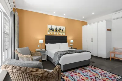 a hotel room with a bed and a chair at Park Hotel Mokopane in Mokopane