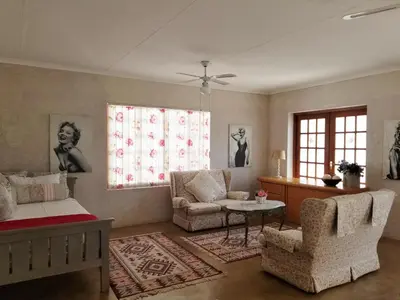a living room with a couch and chairs and windows at Lavender House in White River