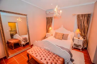 a bedroom with a large bed and a mirror at Lavender House in White River