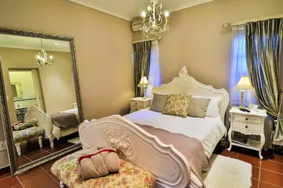 a bedroom with a large bed and a mirror at Lavender House in White River