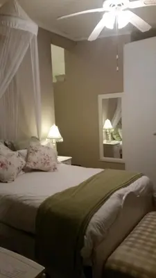 a bedroom with a bed with a ceiling fan at Lavender House in White River
