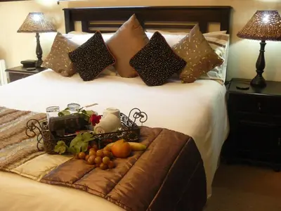 a bed with a tray of fruit on it at Villa Xanelle Boutique Guest House in Centurion