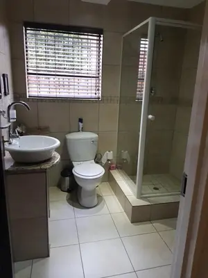 a bathroom with a toilet and a shower and a sink at Villa Xanelle Boutique Guest House in Centurion
