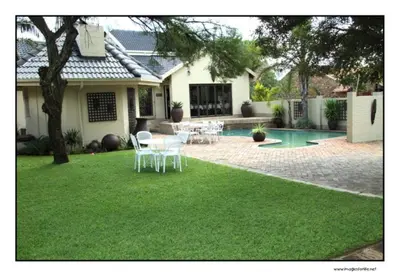 a yard with a house with a table and chairs at Villa Xanelle Boutique Guest House in Centurion