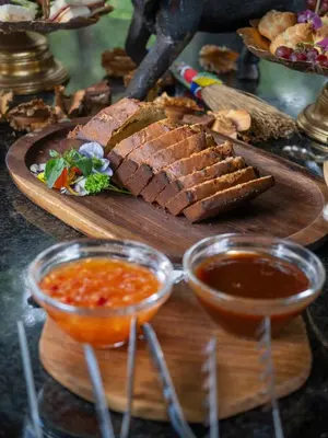 a plate of food with meat and dipping sauce at Ndlovu Safari Lodge in Welgevonden Game Reserve