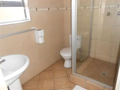 a bathroom with a shower and a toilet and a sink at Platinum Lodge Polokwane in Polokwane