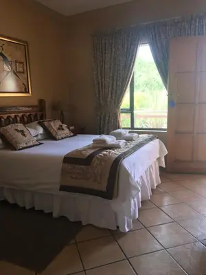 a bedroom with a large bed and a window at Platinum Lodge Polokwane in Polokwane
