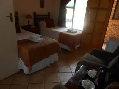 a hotel room with two beds and a couch at Platinum Lodge Polokwane in Polokwane