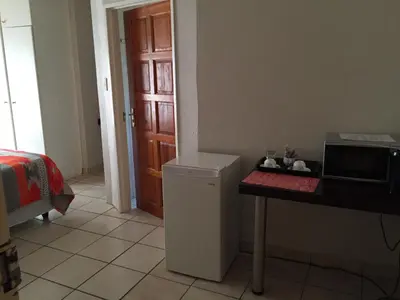 a kitchen with a counter and a table with a microwave at Tropical Paradise Guest House in Nelspruit