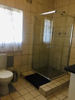 a shower stall in a bathroom with a toilet at Tropical Paradise Guest House in Nelspruit