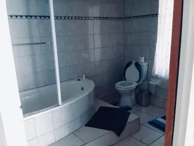 a bathroom with a bath tub and a toilet at Tropical Paradise Guest House in Nelspruit