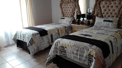 a bedroom with two beds and a headboard at Tropical Paradise Guest House in Nelspruit