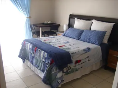 a bedroom with a large bed with blue pillows at Tropical Paradise Guest House in Nelspruit