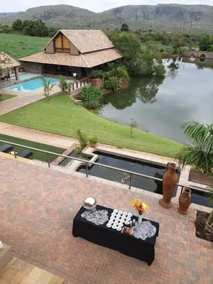 a view of a house and a pool with a table at Nkomazi Kruger Lodge & Spa in Malelane