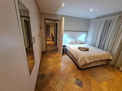a bedroom with a bed and a hallway with a mirror at 282 Guesthouse/Self-Catering in Centurion