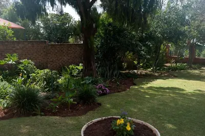 a garden with a tree and flowers in a yard at 282 Guesthouse/Self-Catering in Centurion