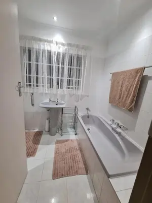 a white bathroom with a tub and a sink at 282 Guesthouse/Self-Catering in Centurion