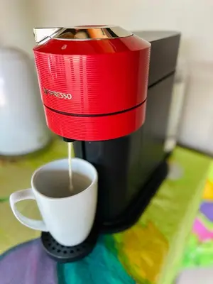 a red coffee maker is making a cup of coffee at Wild Dog Guest Lodge in Hoedspruit