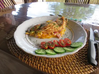 a plate of food with vegetables on a table at Wild Dog Guest Lodge in Hoedspruit