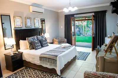a bedroom with a bed and a door to a yard at Four Seasons Guesthouses in Lephalale