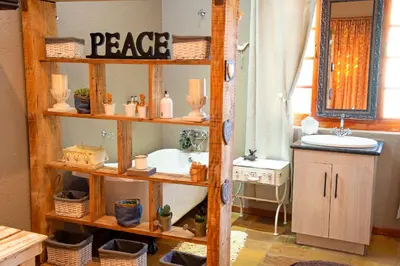 a bathroom with a wooden shelf with a sink and a tub at Four Seasons Guesthouses in Lephalale