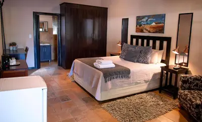 a bedroom with a bed and a couch at Four Seasons Guesthouses in Lephalale