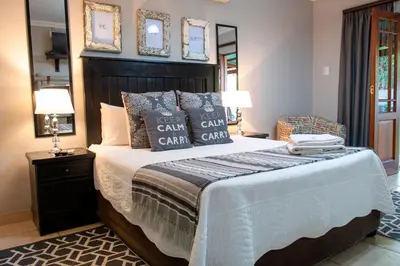 a bedroom with a large bed with pillows on it at Four Seasons Guesthouses in Lephalale
