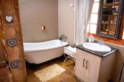 a bathroom with a bath tub and a sink at Four Seasons Guesthouses in Lephalale