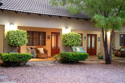 a house with orange doors and a patio at Four Seasons Guesthouses in Lephalale