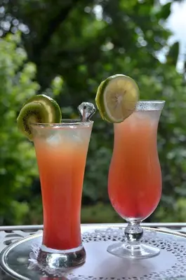 two cocktails on a table with lime slices on it at Highgrove House Country Hotel, Restaurant, Farm & Spa in Hazyview