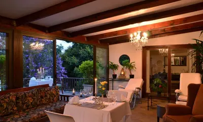 a restaurant with tables and chairs and a large window at Highgrove House Country Hotel, Restaurant, Farm & Spa in Hazyview